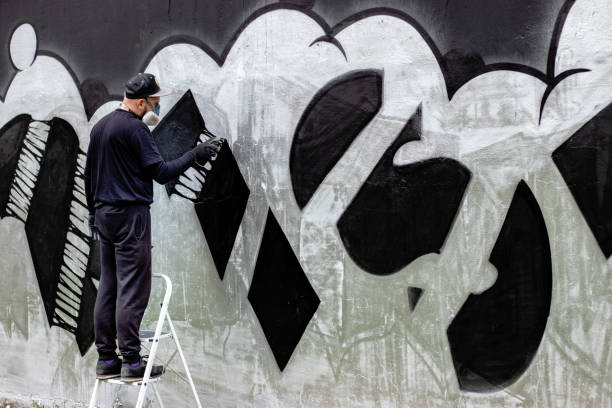 istock Graffiti artist in action, standing on ladders. 1286576233