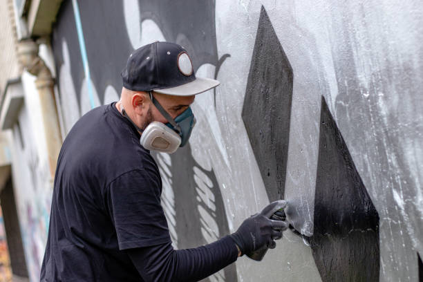 istock Graffiti artist painting on the wall. 1286576252