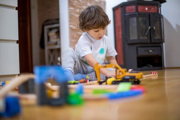 istock Beautiful little boy playing with a railroad train toy. 1286576257