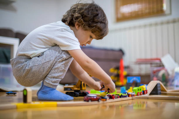 istock Beautiful little boy playing with a railroad train toy. 1286576268