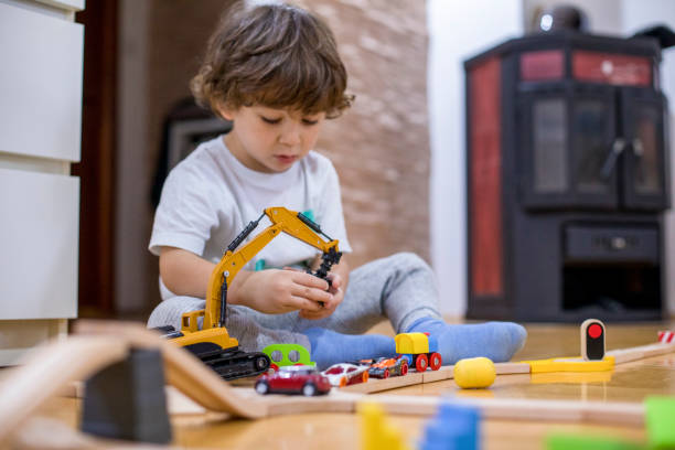 istock Beautiful little boy playing with a railroad train toy. 1286576372