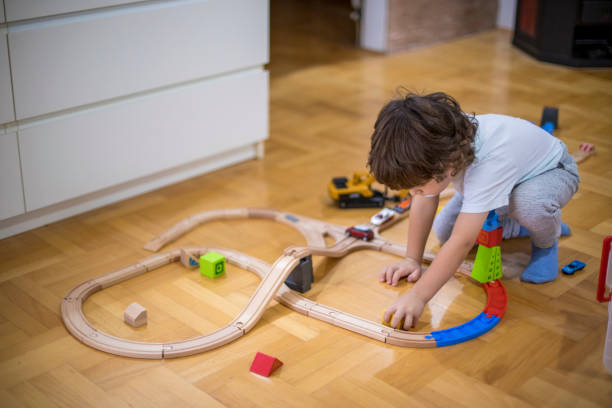 istock Beautiful little boy playing with a railroad train toy. 1286576376