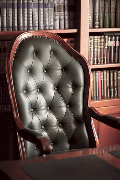 istock Dark solid interior of old library with books on the wooden shelves. 1286577388