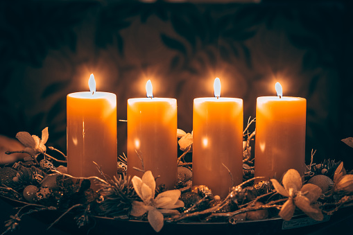 four burning candles with traditional festive cristian atmosphere full of light and magic