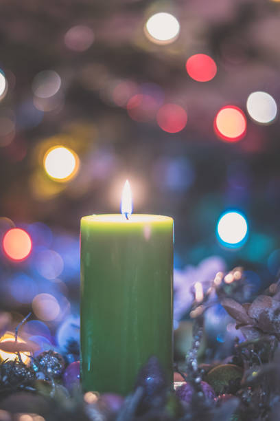 istock Merry Christmas concept with green burning candle shining illuminated christmas tree background with bokeh effect 1286577681