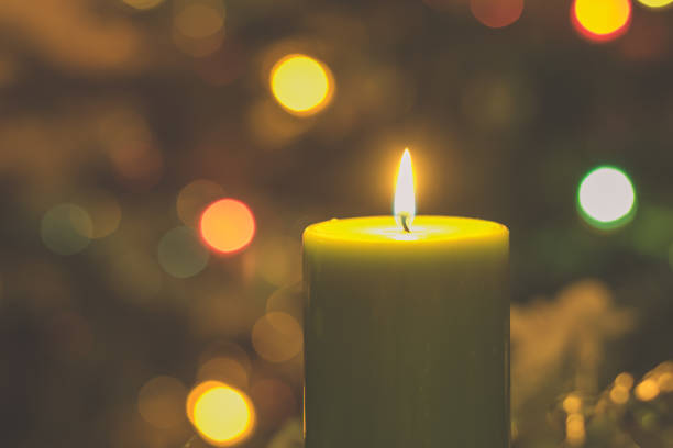 istock Merry Christmas concept with green burning candle shining illuminated christmas tree background with bokeh effect 1286577685