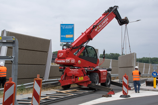Brunssum, the Netherlands, - June 12, 2018. Contractor installing a new glass and concrete sound barrier near the new highway in the country