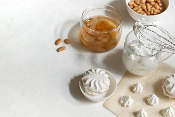 Cup with whipped aquafaba, for making marshmallows and meringues. jar with aquafaba and white beans, on a white background stock photo