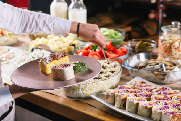 istock Woman taking food from a buffet table close up 1286579823