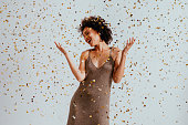 Party Time: Cheerful Young African American Woman Dancing in Confetti Rain (White Background)