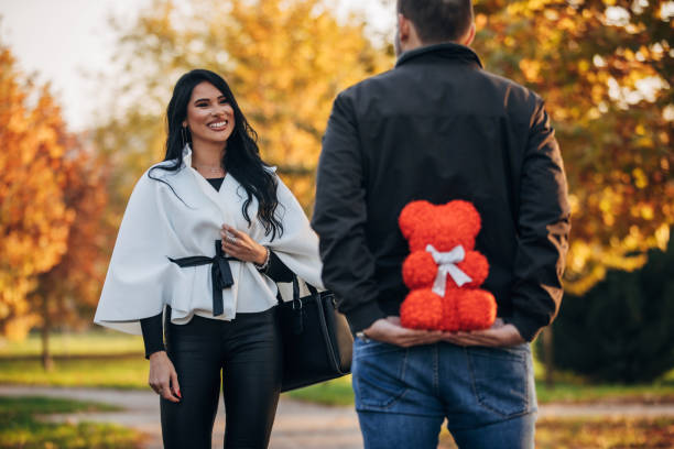 istock Rear view of one young man hiding present from his girlfriend 1286583349