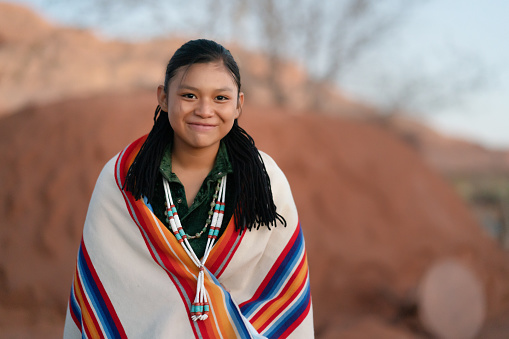 Navajo young girl portrait making funny faces in front of her family hogan