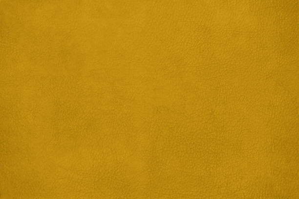 istock Leather texture background surface. Close-up, toned in Fortuna Gold, colour 2021. 1286583805