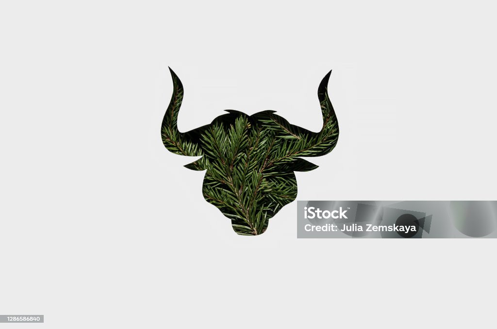 Happy bull year. Christmas tendy card 2021.  silhouette of a green bull Happy bull year. Christmas tendy card 2021.  silhouette of a green bull with a Christmas trees on its body. Chinese Zodiac. Chinese new year 2021. paper cut style. paper cut bull. Christmas Stock Photo