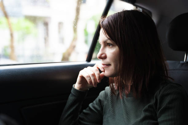 istock Thinkful Woman Looking out a car Window 1286587647