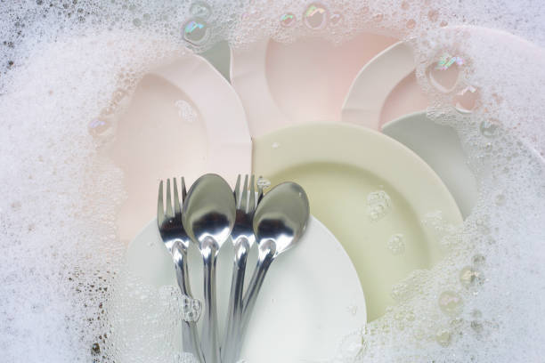 istock Washing dishes, Close up of utensils soaking in kitchen sink. 1286590499
