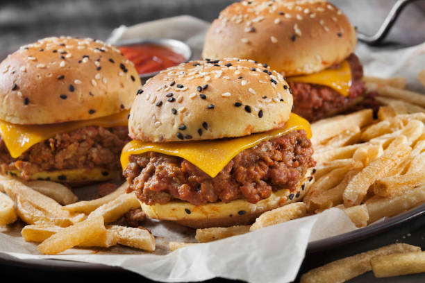 sloppy joe sliders with cheddar cheese on a brioche sesame seed bun with fries - sesame bun american culture cheddar imagens e fotografias de stock