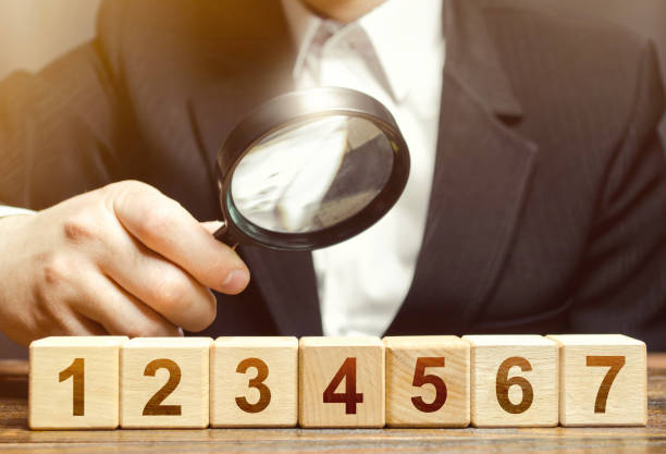 istock Man examines the numbered blocks with a magnifying glass. Study business plan instructions, contract roadmap. Organization and systematization processes. Education and passing the study course. 1286590722