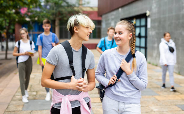 istock Students with backpacks and notebooks walk down the street 1286594909