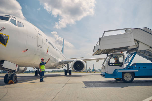 Experienced airport worker directing the ground vehicle operator