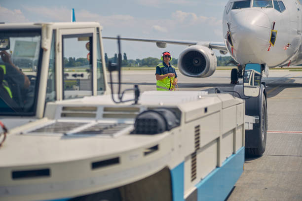 istock Ground crew preparing for towing an airplane 1286597592
