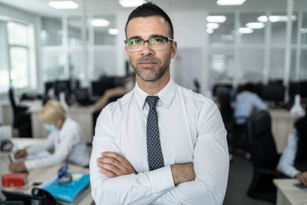 istock Confident business manager standing middle of office 1286598650
