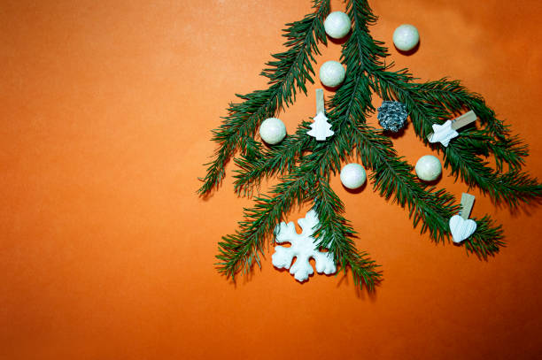 istock Fir branch with christmas decorations on orange background, copy space, selective focus. 1286598817