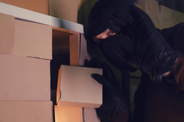 istock A thief takes a box with a parcel in a warehouse at night. Concept of security problems in warehouses and stores 1286598952