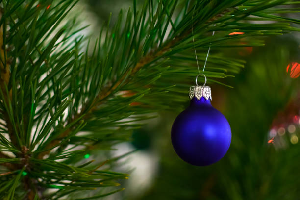 istock Blue ball on green spruce branches on a blurred background. Christmas and New Year decorations. A bauble on a tree. Shallow depth of field 1286599079