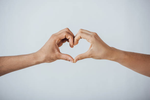 istock Cropped view of men gesturing love sign isolated on grey 1286600821