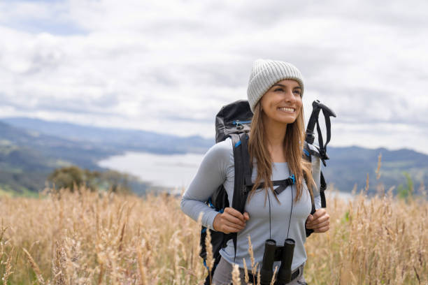 Portrait of a Latin American female hiker looking very happy outdoors carrying her backpack and smiling