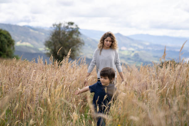 Happy Latin American mother and son enjoying the nature while walking in the mountains - lifestyle concepts