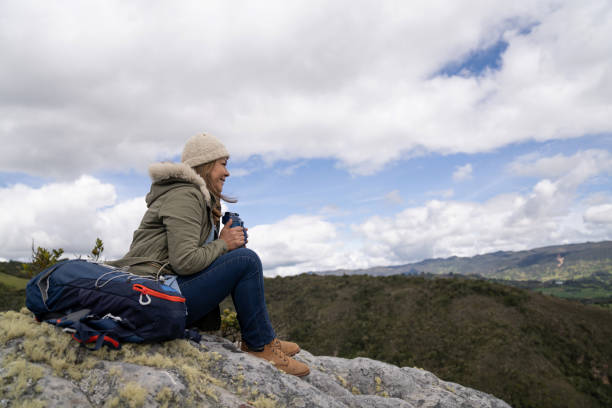 istock Female hiker looking very happy outdoors enjoying nature and drinking some water 1286610240