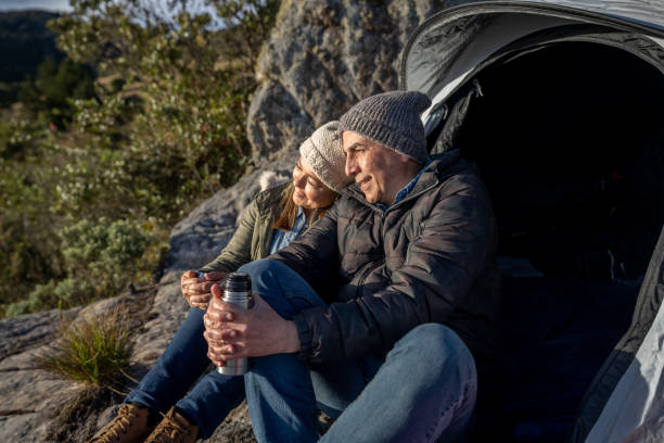 istock Loving couple camping and drinking coffee outside their tent 1286610294