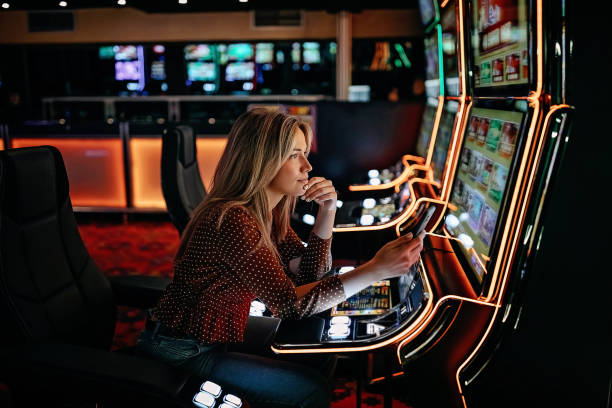 Women gambling on slot machinery stock photo