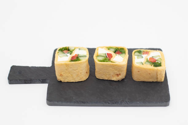 istock Tortilla rolls with vegetables served on a black slate board 1286616536