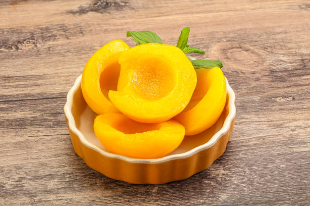 Sweet ripe canned peaches with mint leaves