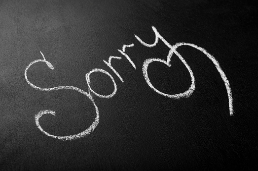 Inscription in white chalk on a black board, Sorry. The concept of an apology, asking for forgiveness from the heart. Copy space