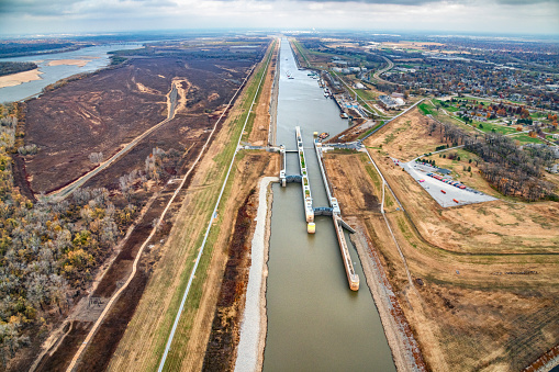 A lock on a man-made tributary diverting water from the natural river to the east  to overcome the annual variances in water depth on the river in order to maintain the shipping trade along the Mississippi River in the central United States.  This aerial view is just outside of St. Louis, Missouri on the Illinois side of the river.