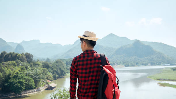 istock Young hipster man traveling with a backpack in summer forest 1286625030