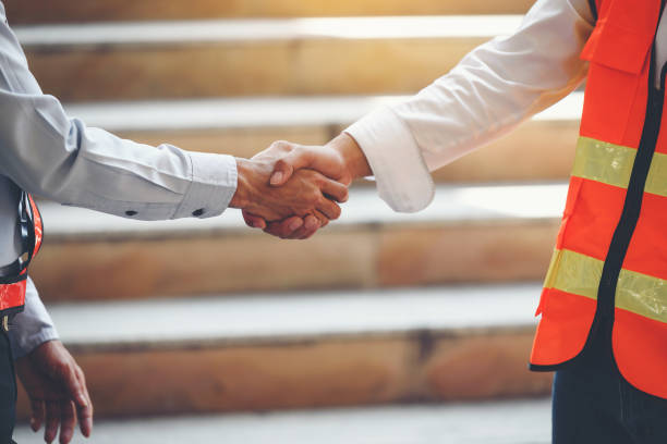 istock The hands of the engineer and the builder were holding a handshake and reached an agreement. 1286625321