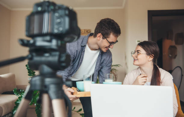 istock Caucasian couple with glasses are having the meal while working with laptop and camera remotely 1286627567
