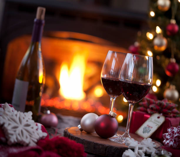istock Christmas red wine and a gift in front of a fireplace. 1286629465