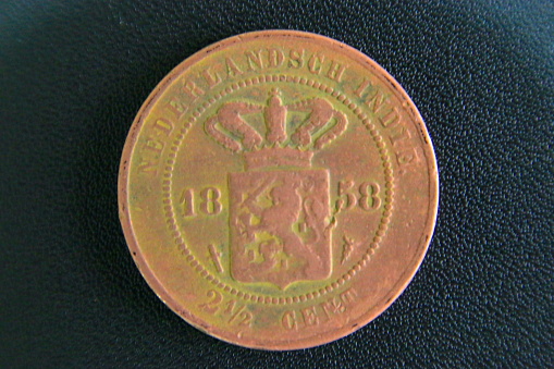 There is an indie Nederlandsch writing 2.5 cent in the outer circle. While the inner circle has the inscription of the year of Manufacture in 1858 and the emblem of the Crowned and the sea horse. The other side has Javanese writing which reads \