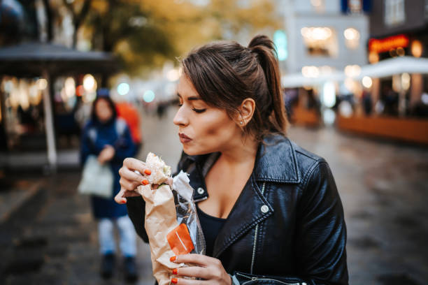istock Young woman eating in the city 1286631347