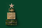 Christmas composition. Three gifts laid out in the shape of a Christmas tree with star on top.