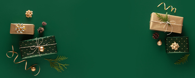 Gifts in wrapping paper on green background. Copy space.