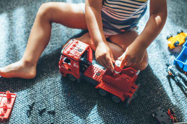 istock Upper view photo of a caucasian boy playing with a constructor car on the floor 1286632396