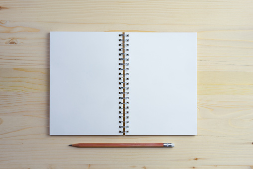 Top view open blank notebook and pencil on a light wooden table, copy space
