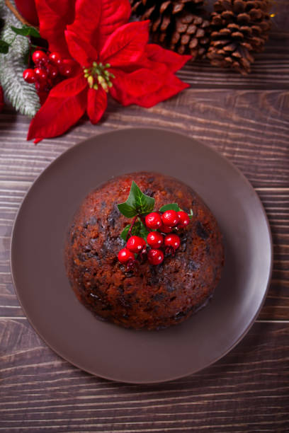 istock Traditional Christmas pudding with holly on top on the wooden background 1286634530